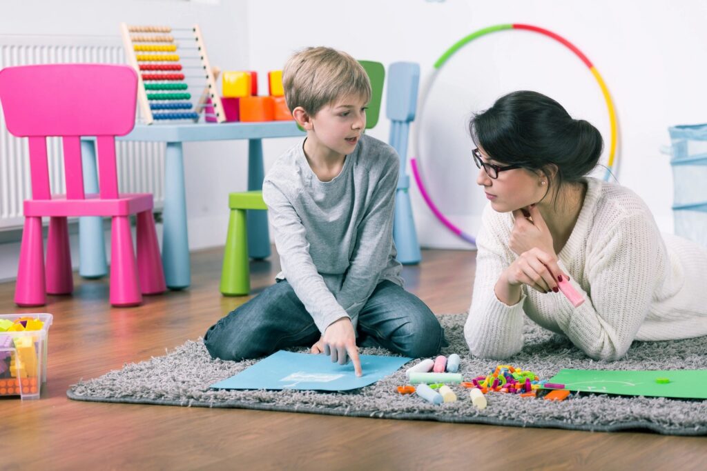 Therapist and child working together on the floor